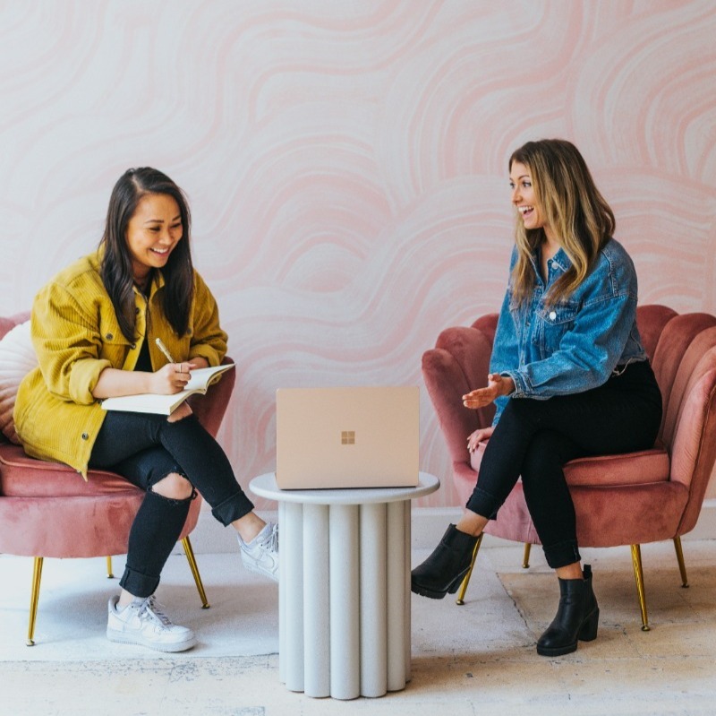 two people discussing infront of a laptop